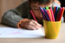 Child coloring with Crayons